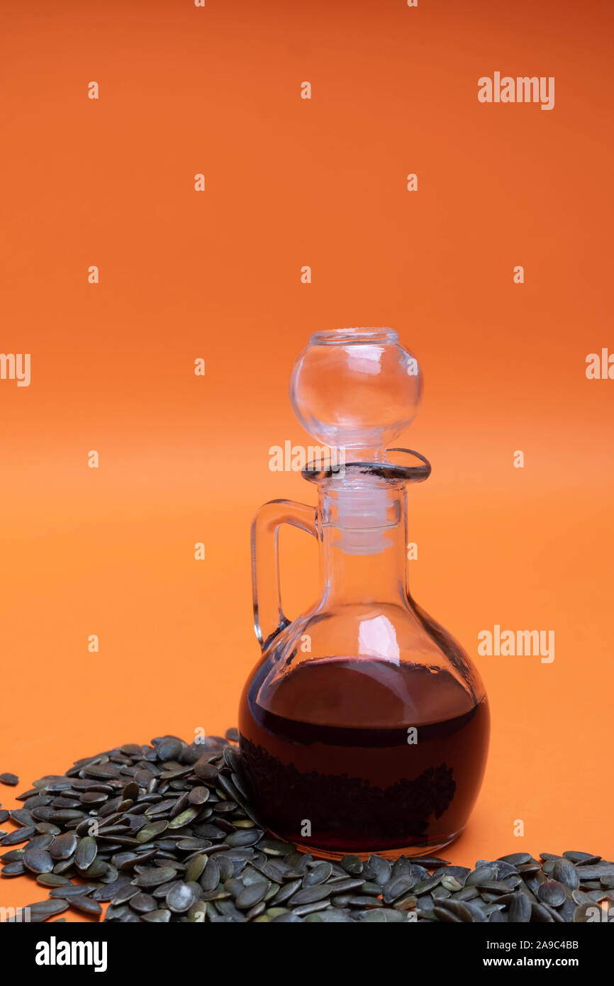 Bouteille de verre d'huile de graines de potiron avec les graines de citrouille Banque D'Images