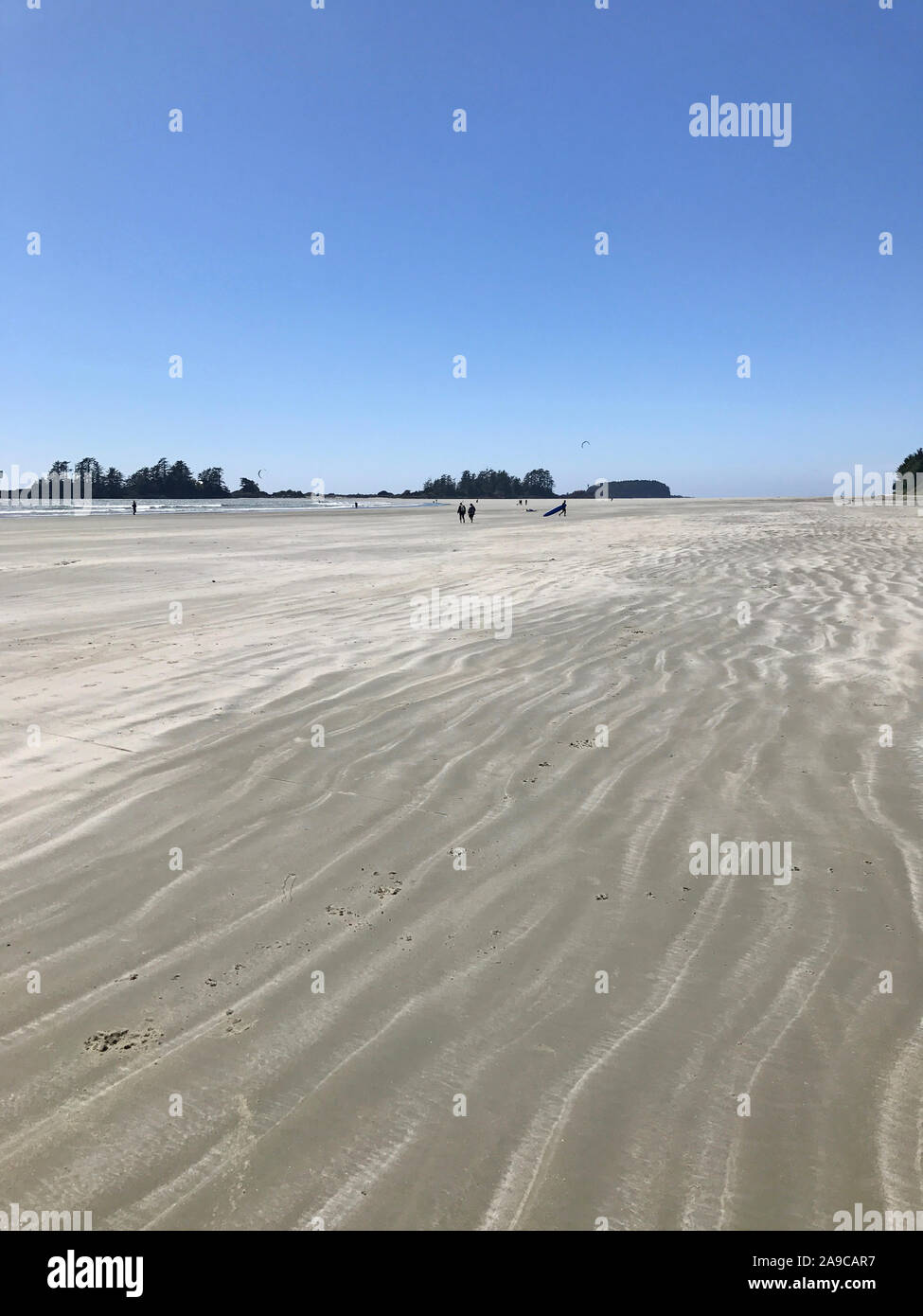 Plage de vent avec texture du sable et de Grand ciel bleu et kite surfeurs Banque D'Images