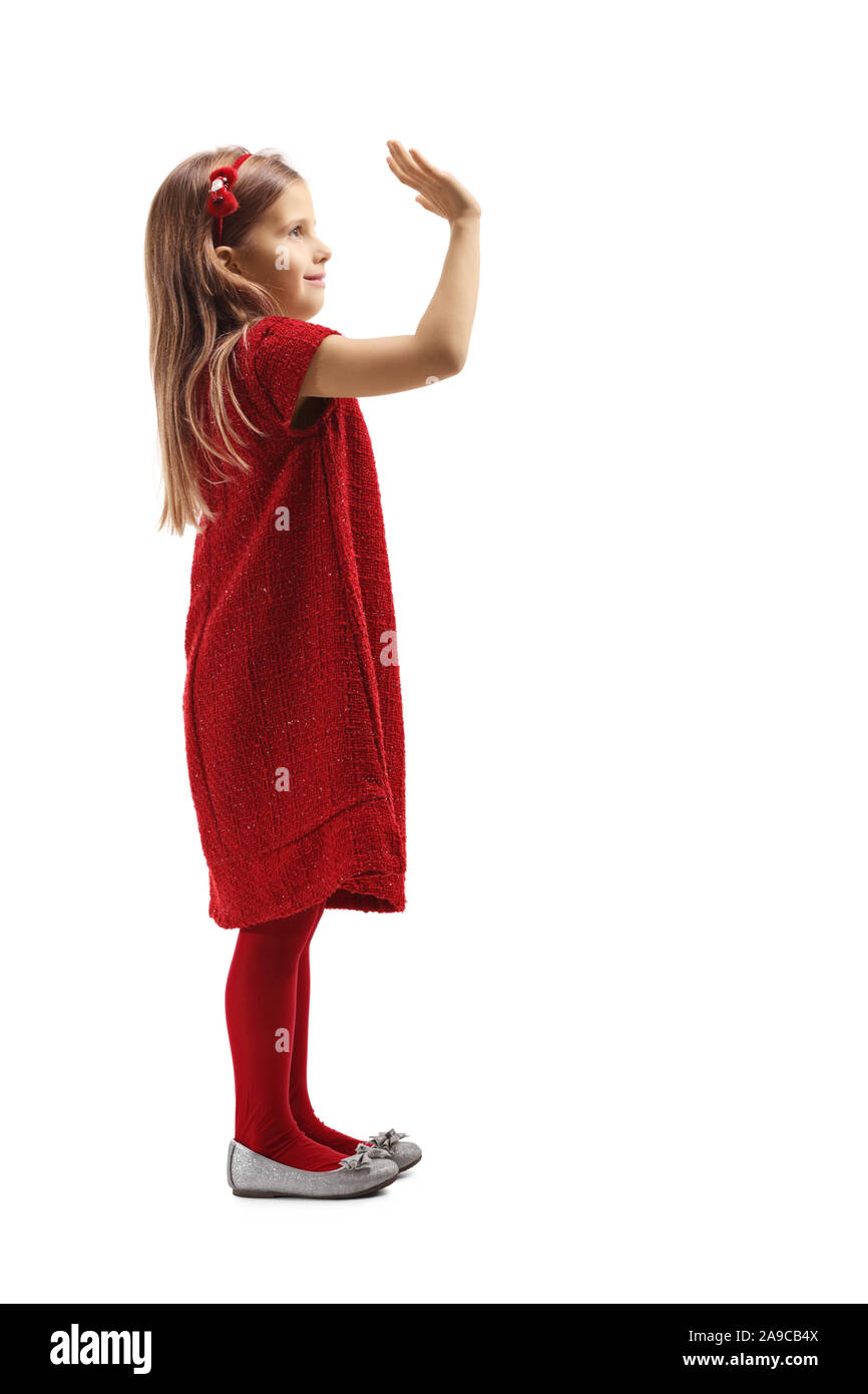 Profil tourné sur toute la longueur d'une petite fille dans une robe rouge avec message d'accueil part isolé sur fond blanc Banque D'Images