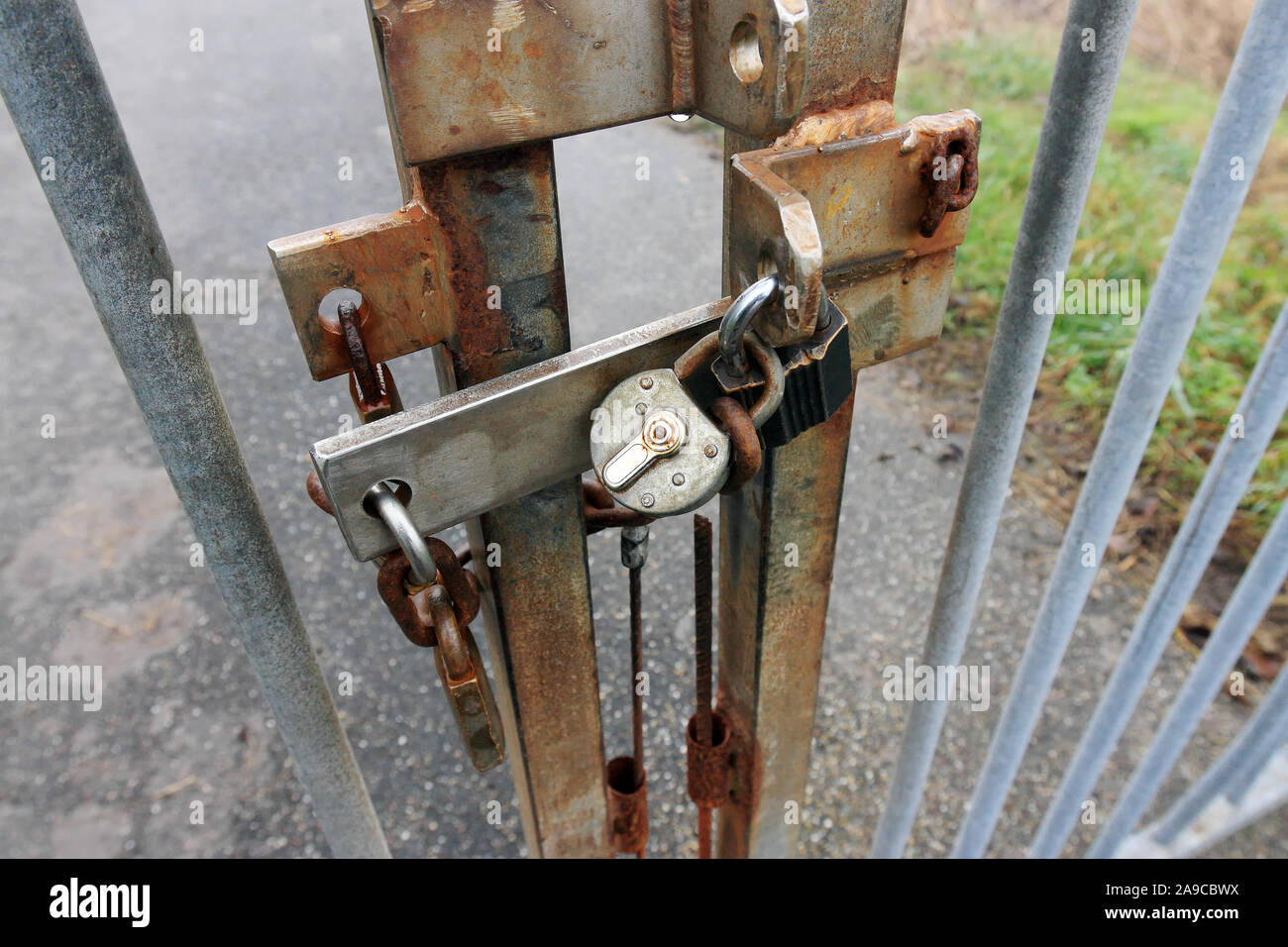 Close-up de la moitié de l'acier rouillé porte avec trois cadenas Banque D'Images