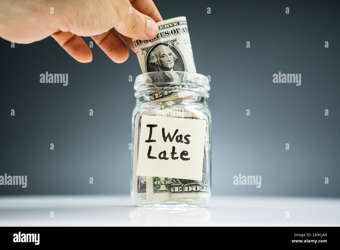 La main de l'homme Mettre l'US Dollar Notes Notes adhésives avec bol en verre Banque D'Images