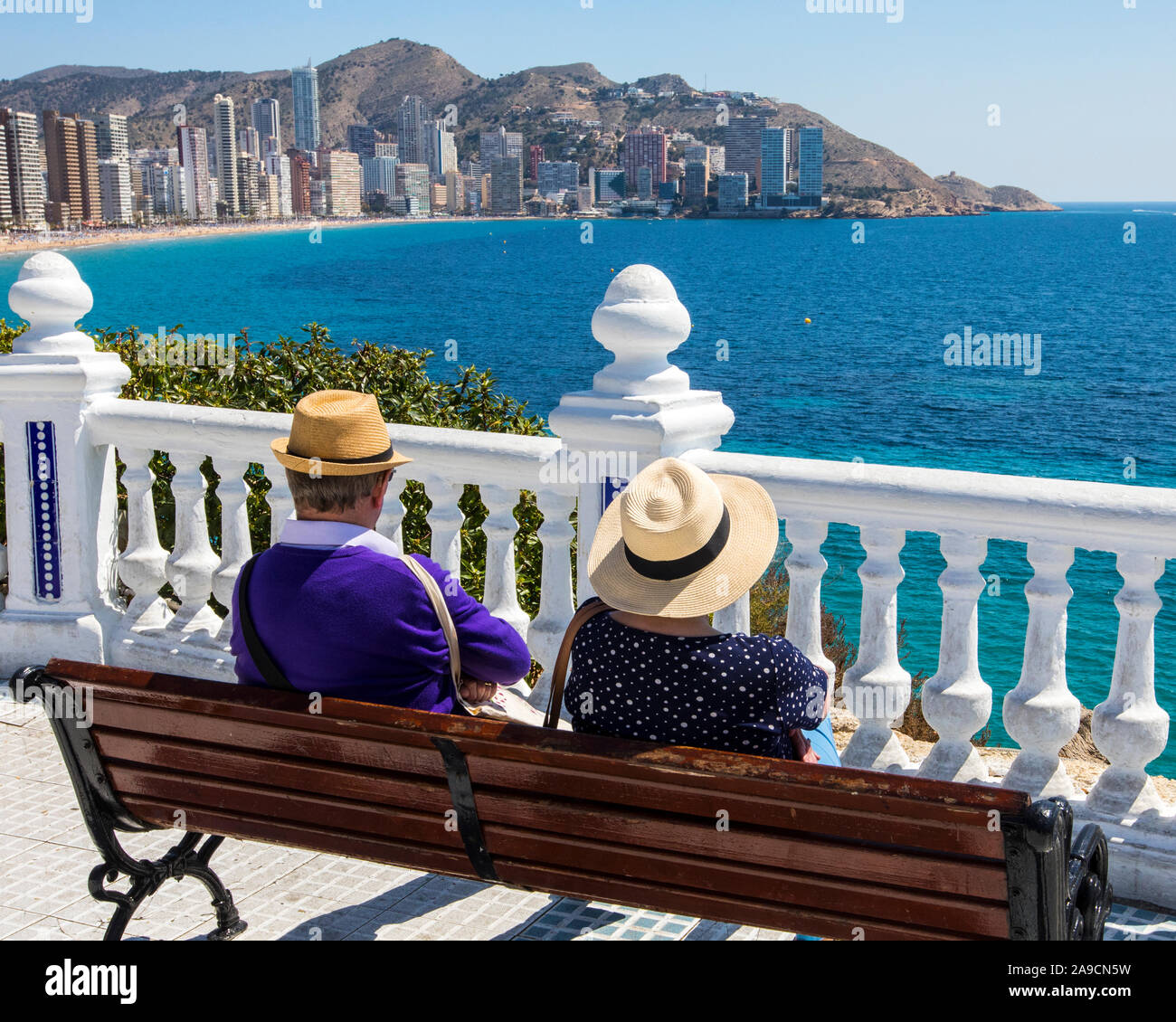 Un couple assis sur un banc à Plaza del Castell donnant sur la plage de  Levante à Benidorm, Espagne Photo Stock - Alamy