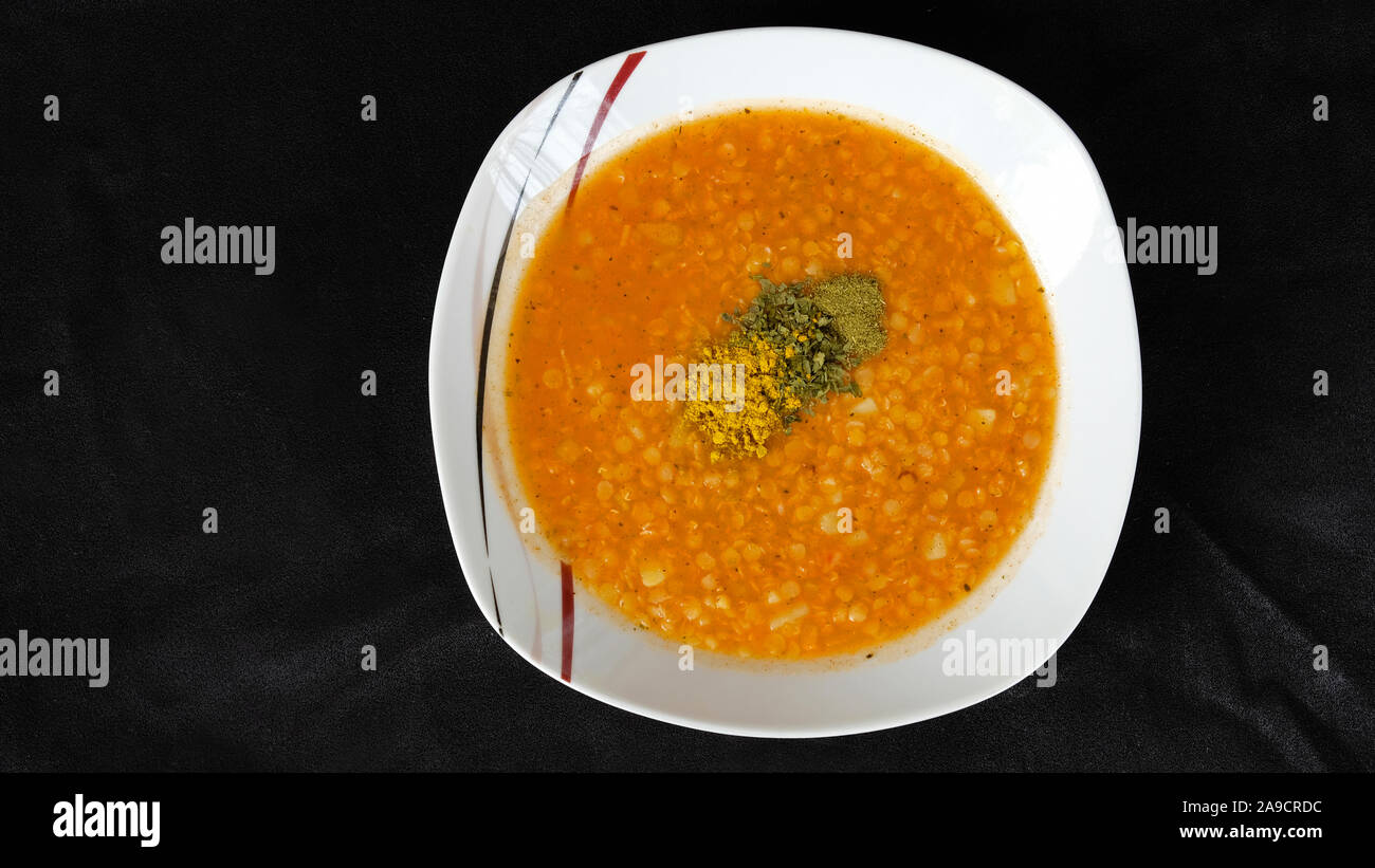 Soupe aux lentilles rouges sur le fond noir Banque D'Images