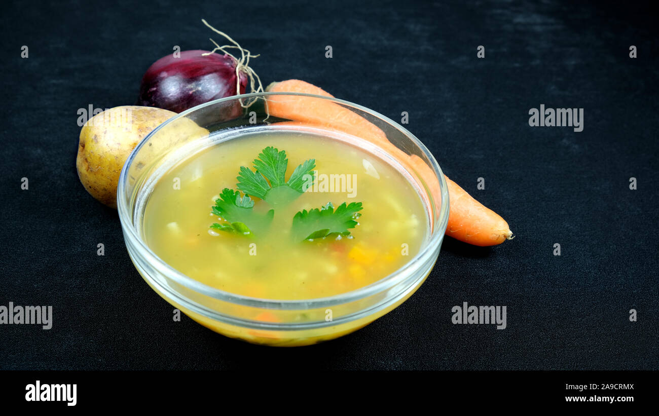 Soupe de légumes sur le fond noir et la carotte,oignon, pomme de decor Banque D'Images