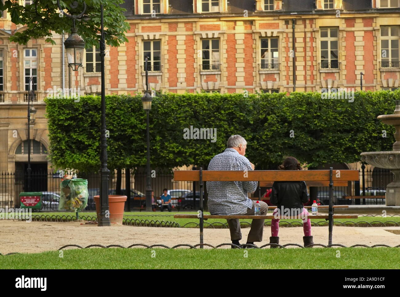 Paris, Ile de France / France - le 19 juin 2016 : grand-père et le petit-enfant s'asseoir sur un banc de parc et profiter de la fin de la journée ensemble Banque D'Images