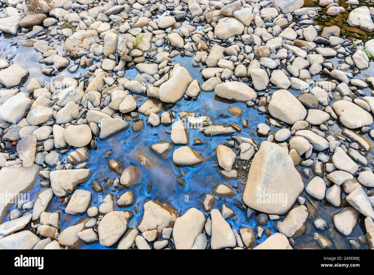 Tache d'huile ou d'essence sale dans la rivière de montagne Banque D'Images