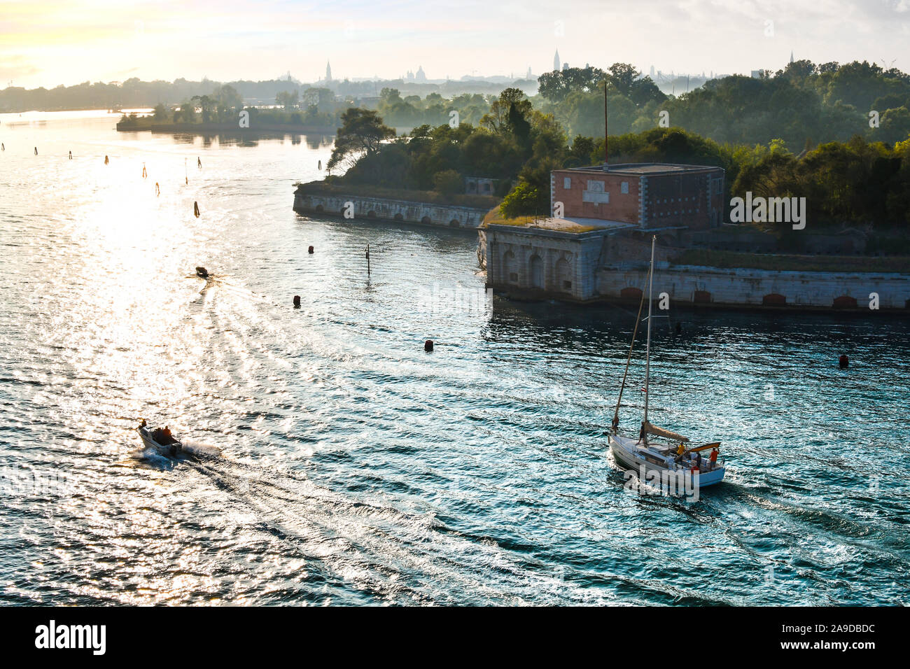 Col bateaux Forte Sant'Andrea sur l'île de Le Vignole en dehors de la lagune principale au coucher du soleil, à Venise, Italie Banque D'Images