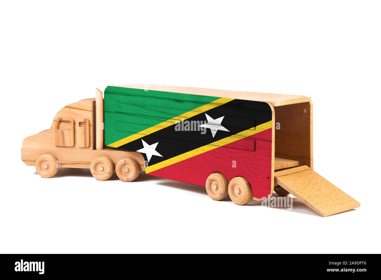 Close-up d'un camion jouet en bois peint avec un drapeau national Saint Kitts et Nevis. Le concept d'exportation-importation, transport, livraison nationale de g Banque D'Images