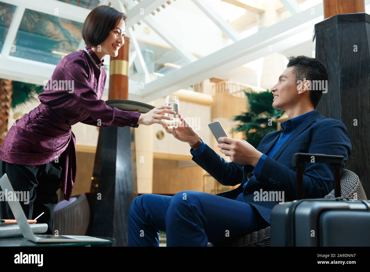 Serveur de l'hôtel apporte au client la fin de l'eau Banque D'Images