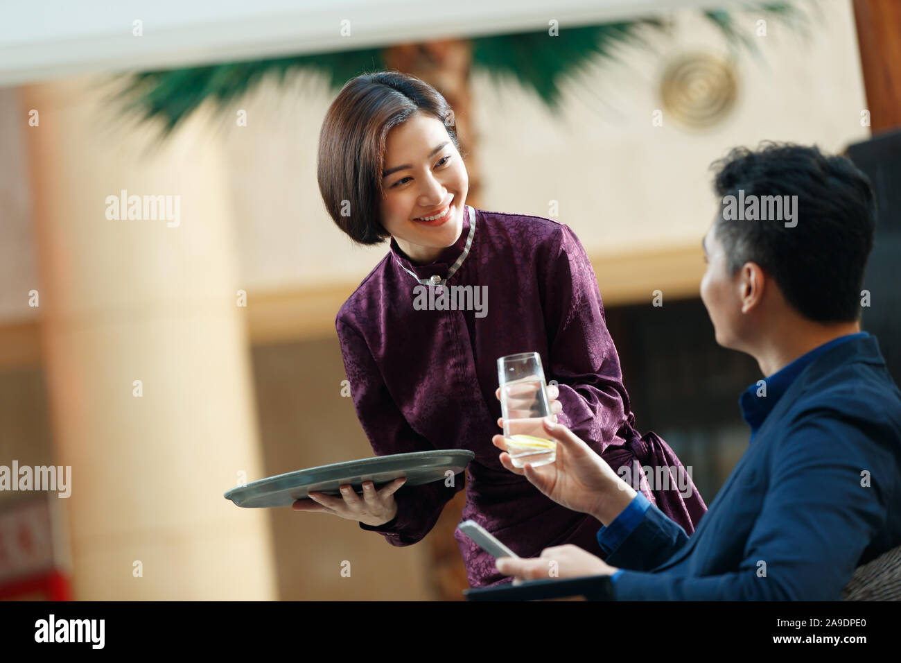 Serveur de l'hôtel apporte au client la fin de l'eau Banque D'Images