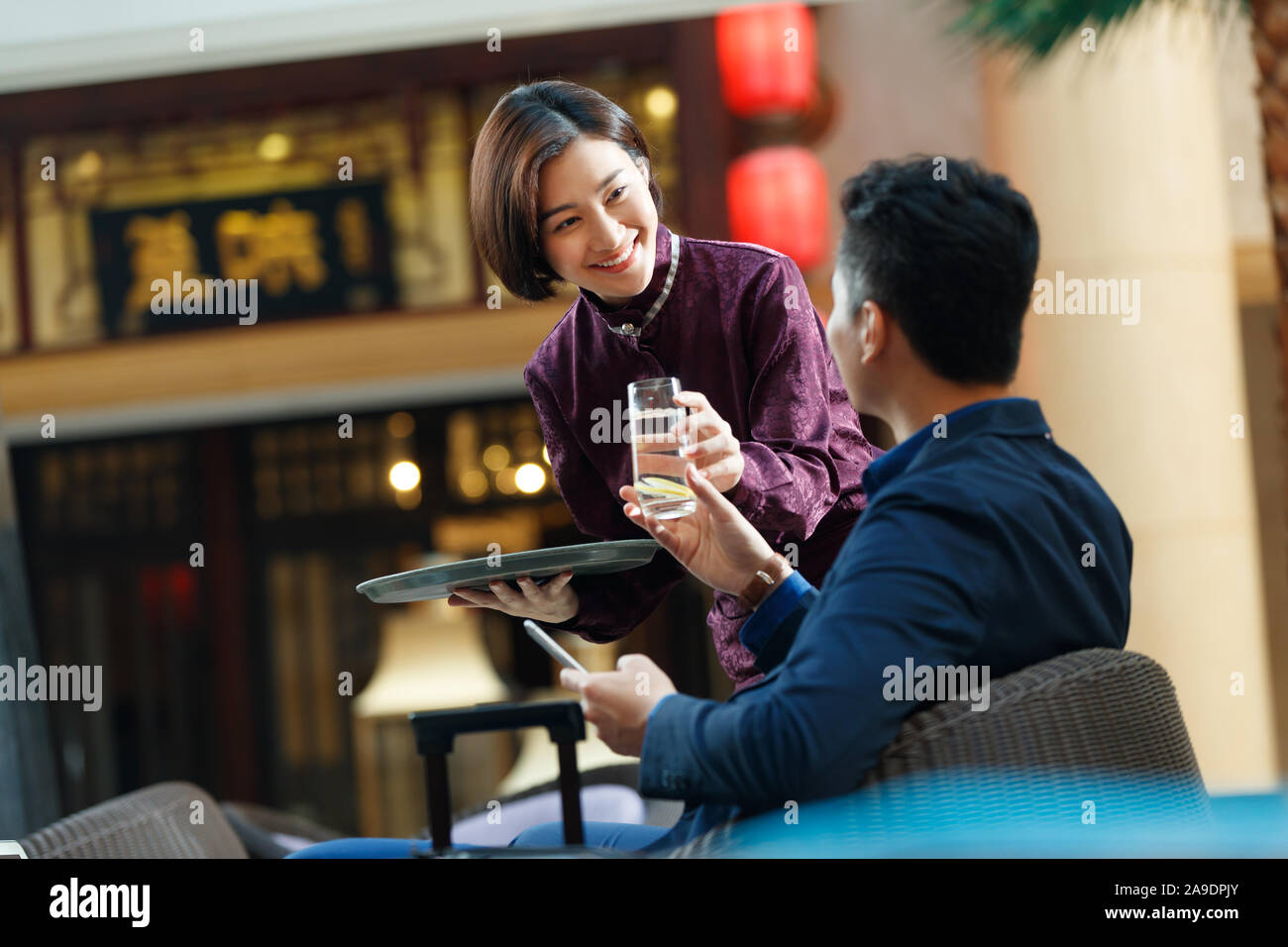 Serveur de l'hôtel apporte au client la fin de l'eau Banque D'Images