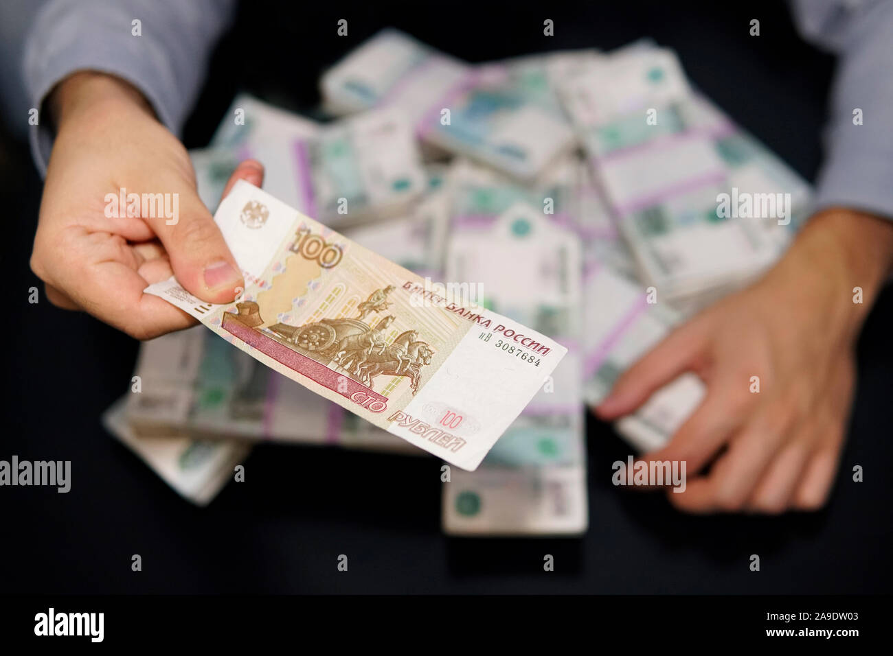 Les mains des hommes cupides pour atteindre une liasse d'argent. Un million de roubles sur le tableau noir. Le concept de la richesse, le succès, la cupidité et la corruption, la luxure f Banque D'Images