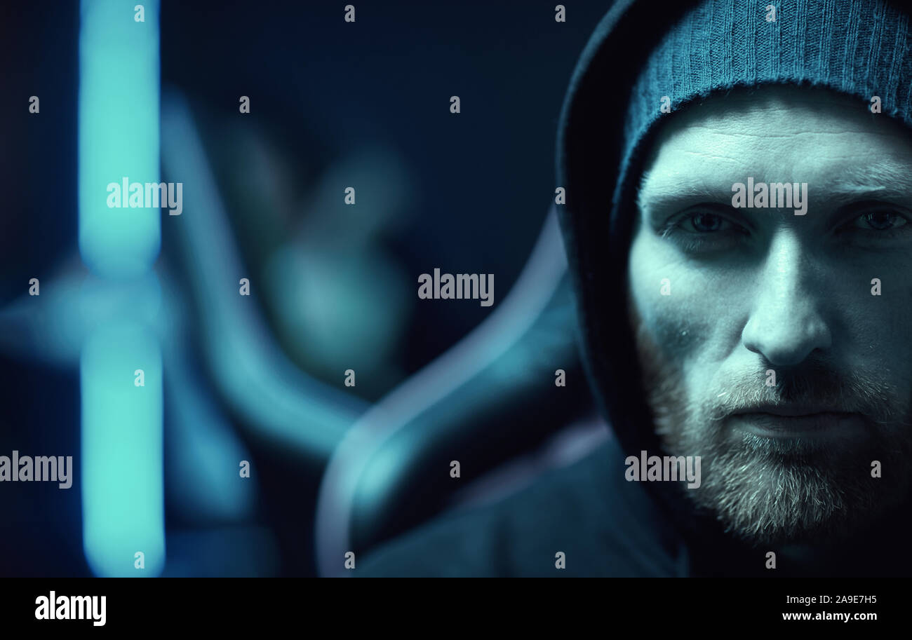 Portrait de jeune homme barbu vêtu de noir, culotte, looking at camera with serious expression Banque D'Images