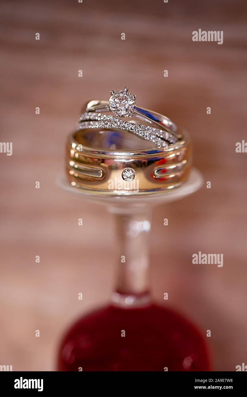 Les anneaux de mariage empilés sur un verre renversé Banque D'Images