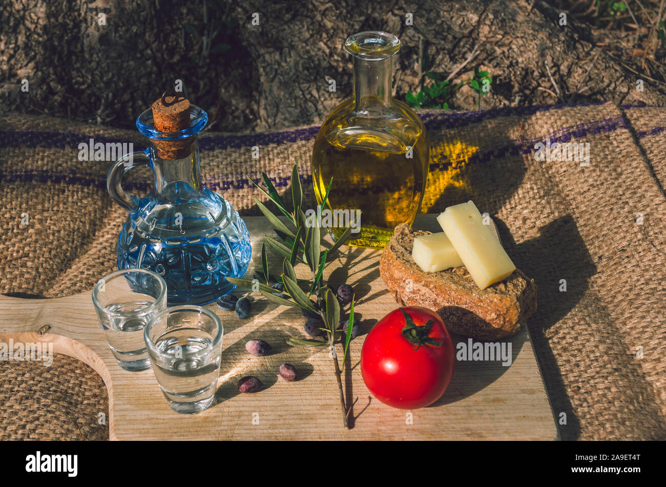 Cuisine crétoise avec l'huile d'olive vierge, olives noires, de l'orge de Crète biscottes, fromage local et carafe de raki crétois. Banque D'Images