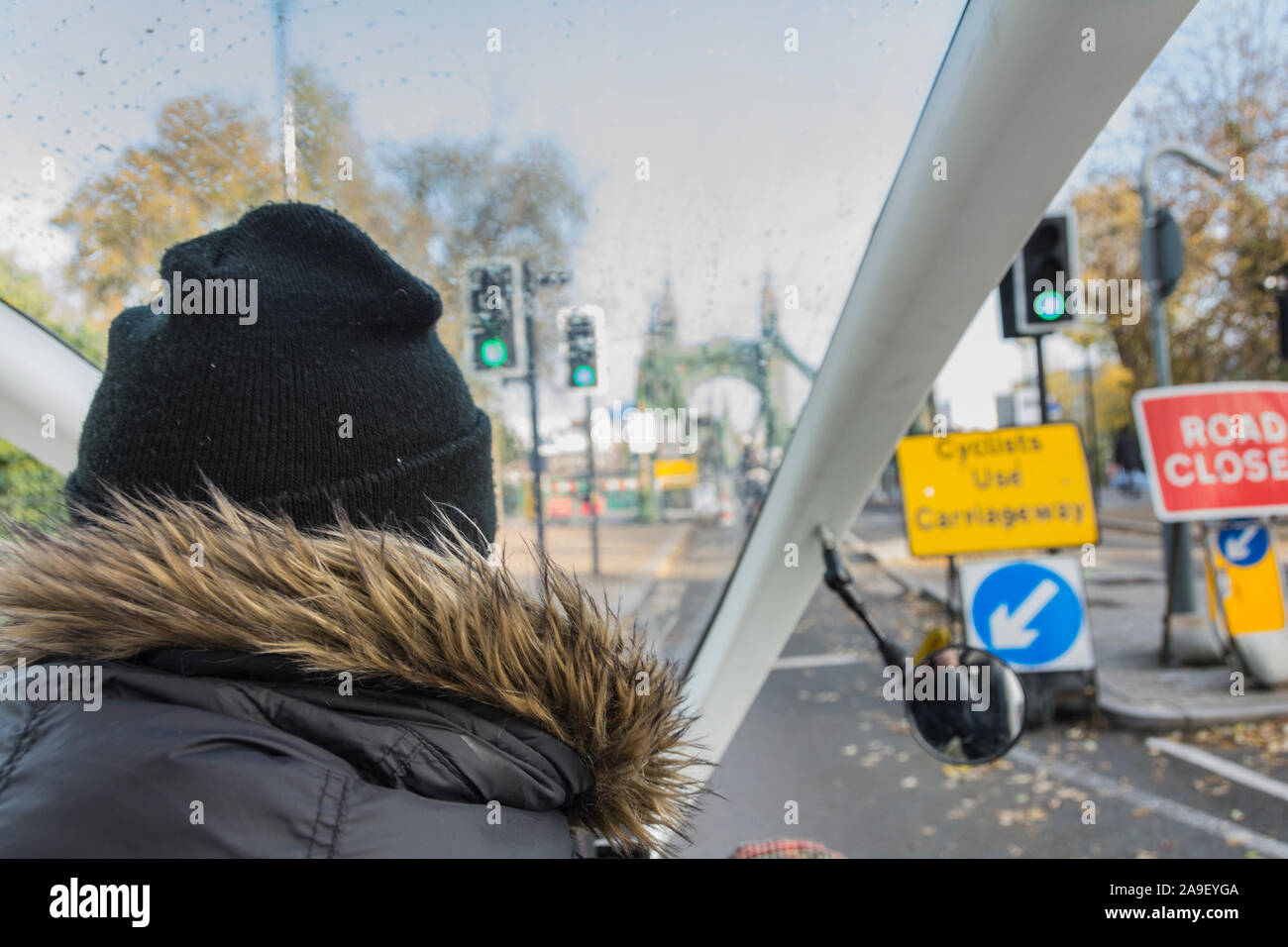 Service de taxi pédale gingembre rider crossing Hammersmith Bridge dans l'ouest de Londres, Royaume-Uni Banque D'Images