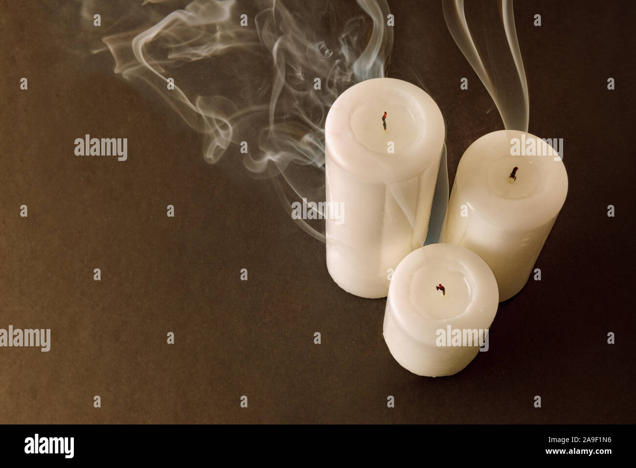 Trois bougies éteintes récemment fumée mèche sur fond marron. Vue d'en haut.  Composition horizontale Photo Stock - Alamy