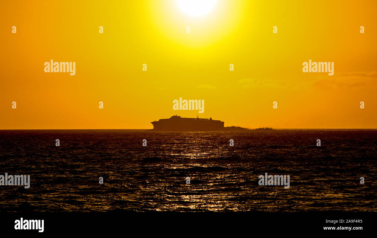 Silhouette d'un grand navire se déplaçant à l'horizon pendant un été magnifique coucher du soleil sur l'océan. Bateau naviguez sur la mer avec coucher du soleil en ba Banque D'Images