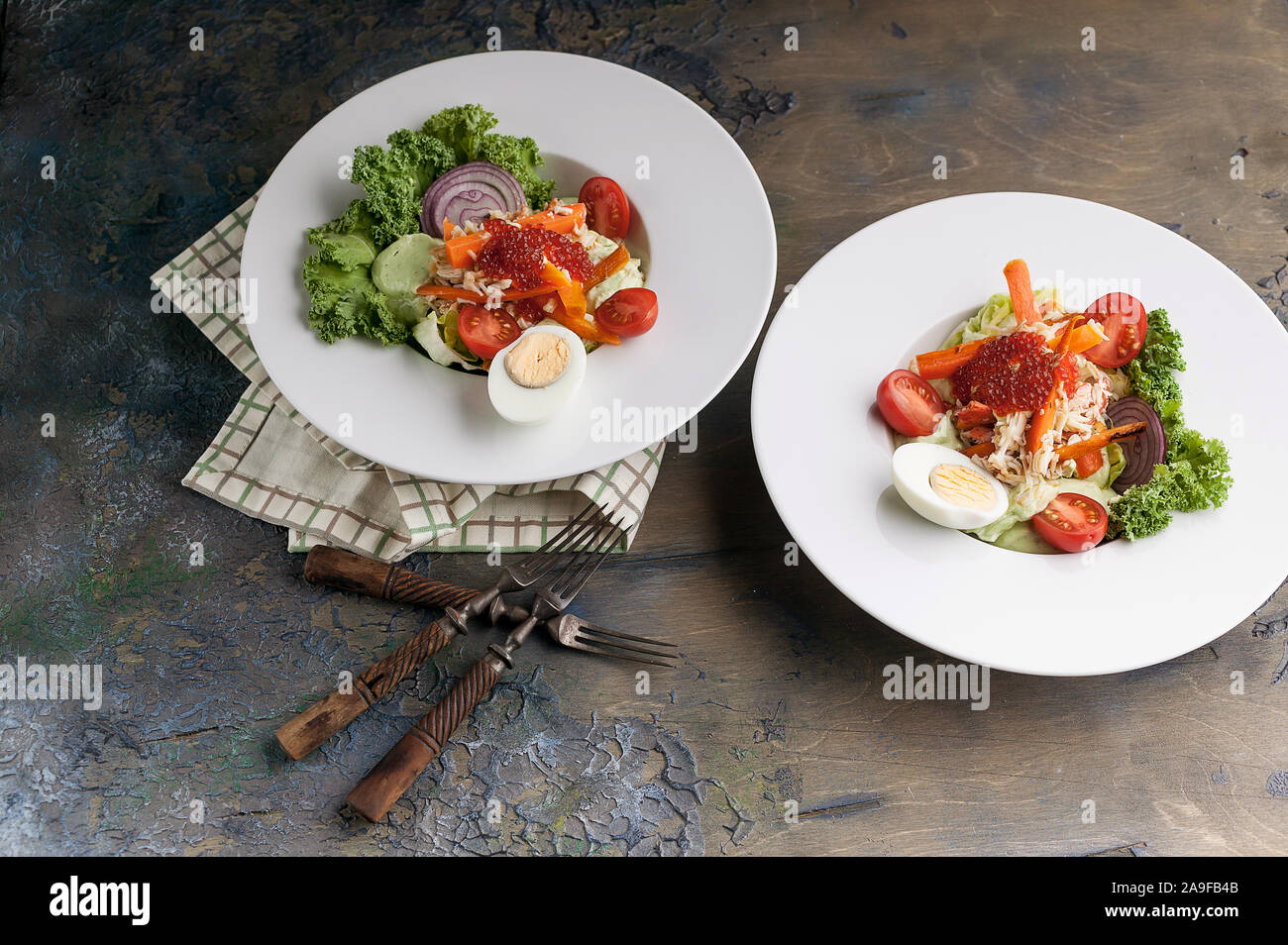 Délicieuse salade à la viande de crabe, avocat, des légumes frais et du caviar de saumon. Servir sur une serviette à carreaux. Plan horizontal Banque D'Images