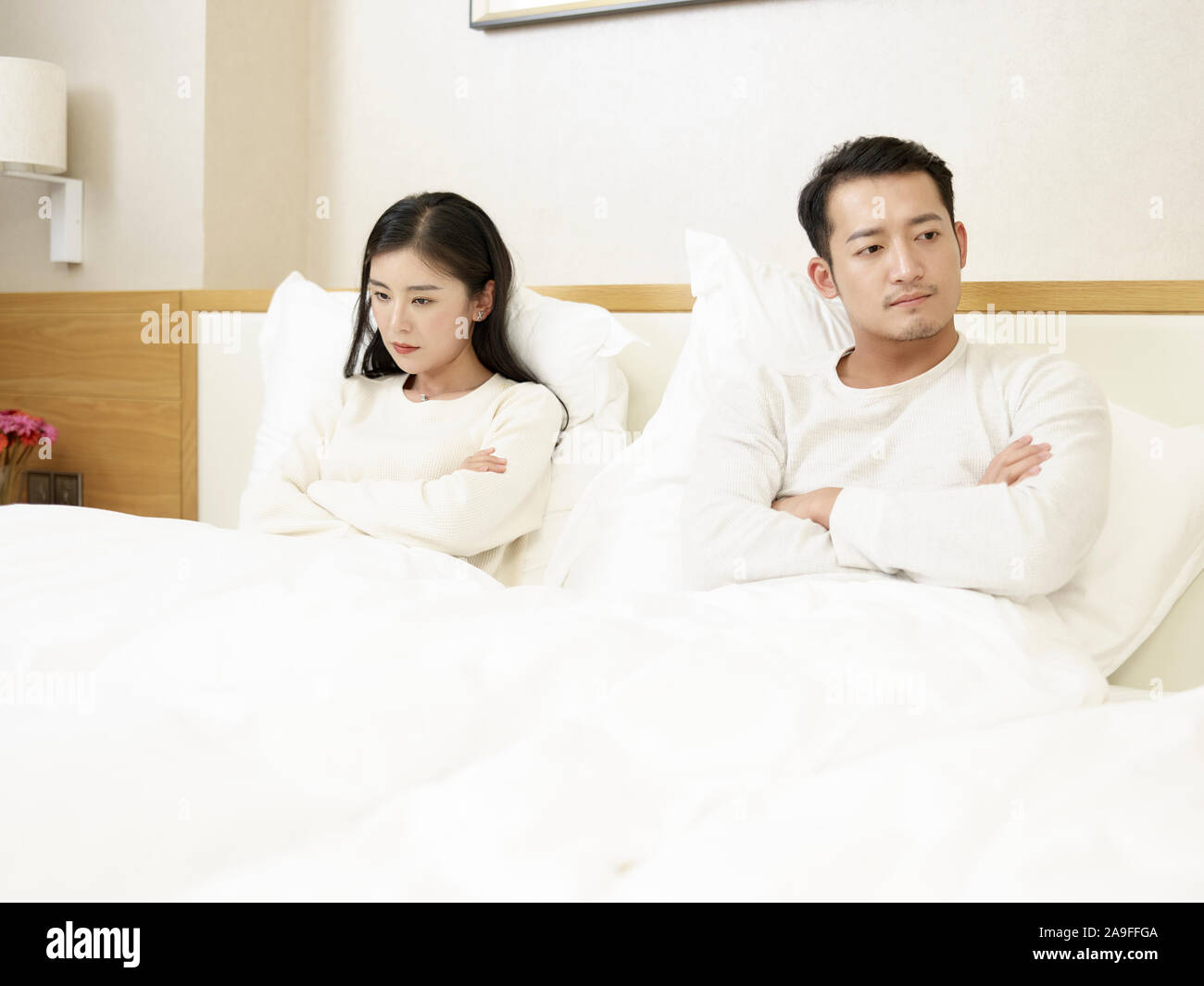 Young Asian Woman sitting in bed en colère les uns avec les autres, l'accent sur la femme Banque D'Images