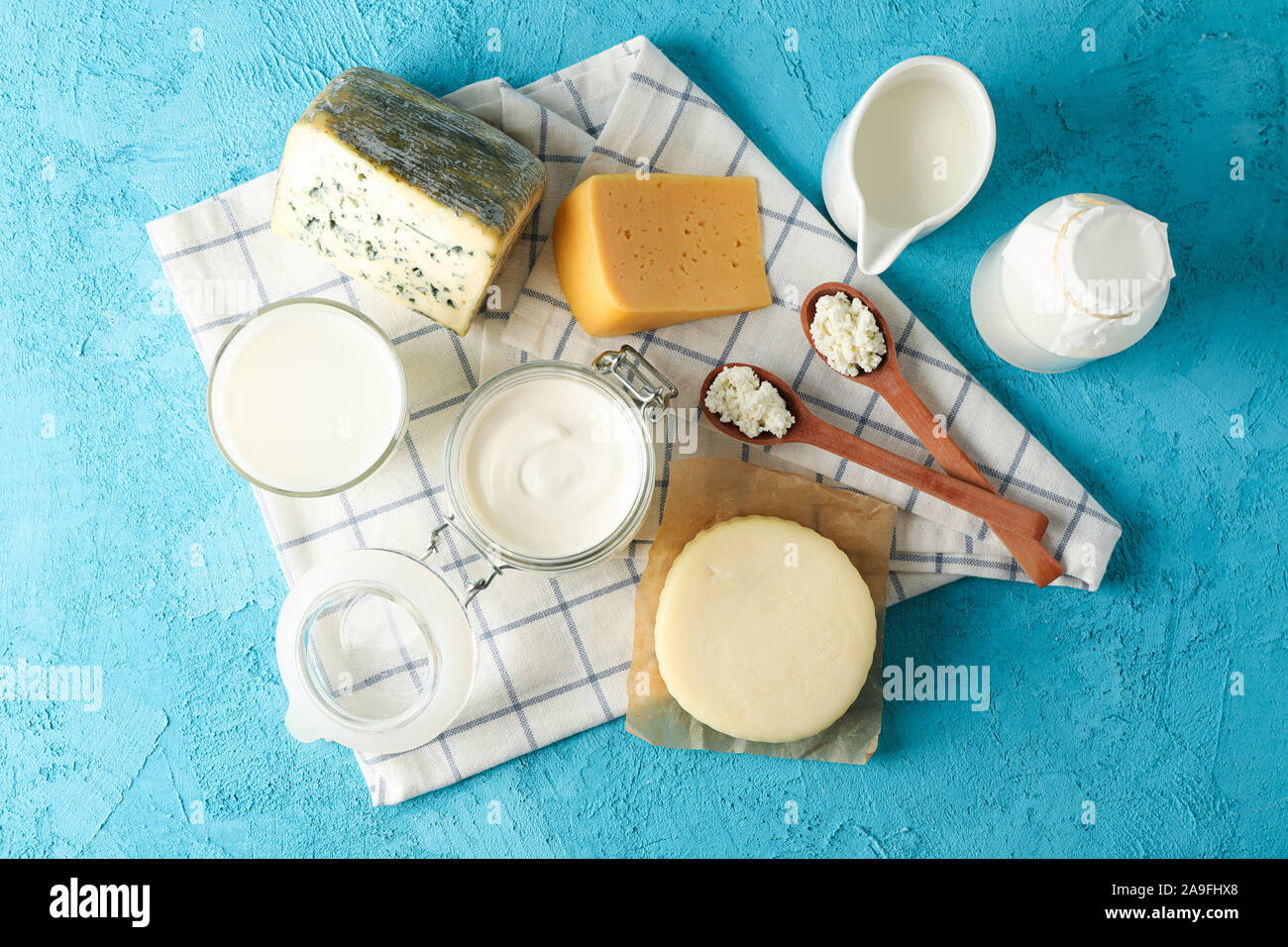 Les produits laitiers frais et cuisine serviette sur fond bleu, vue d'en haut Banque D'Images