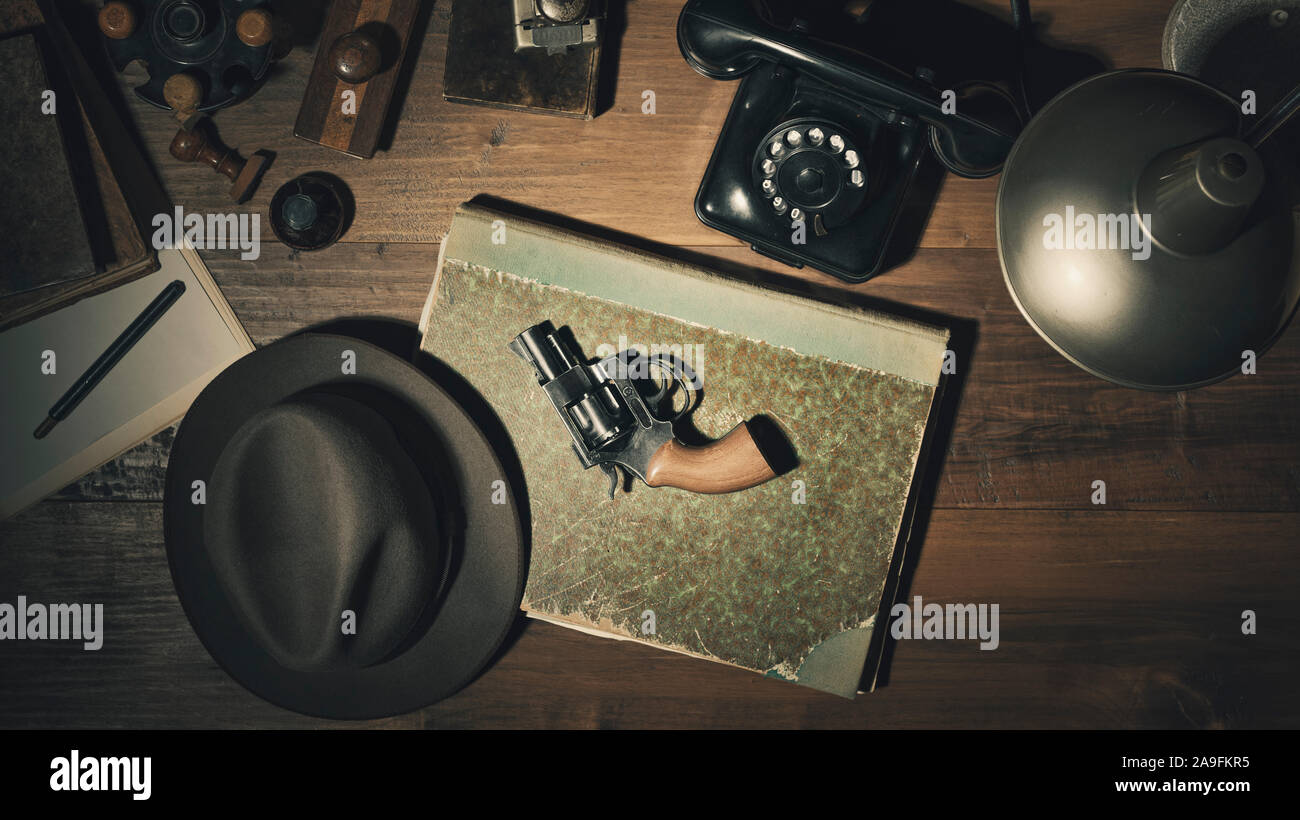Noir 1950 détective style vintage desktop avec revolver, fedora hat et téléphone, télévision lay Banque D'Images