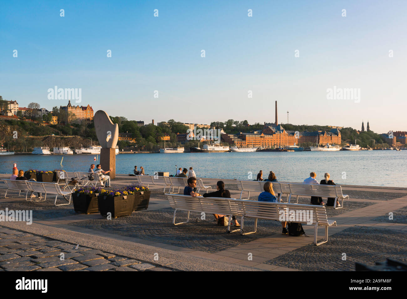 Soirée d'été de Stockholm, vue de personnes sur des bancs de détente situé sur l'esplanade de l'île de Riddarholmen avec vues de Södermalm, le centre de Stockholm. Banque D'Images