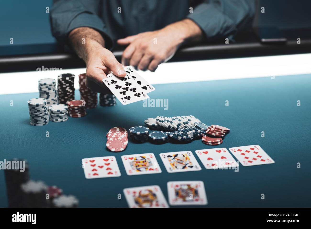 Man playing poker Texas Hold'em au casino, il est maintenant deux cartes Banque D'Images