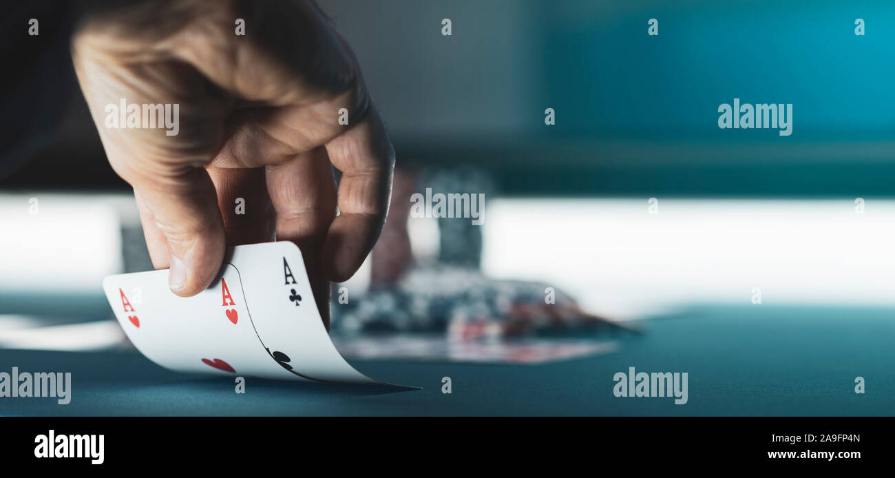 Texas Hold'em Tournoi de poker au casino : un joueur tient deux cartes de ace Banque D'Images