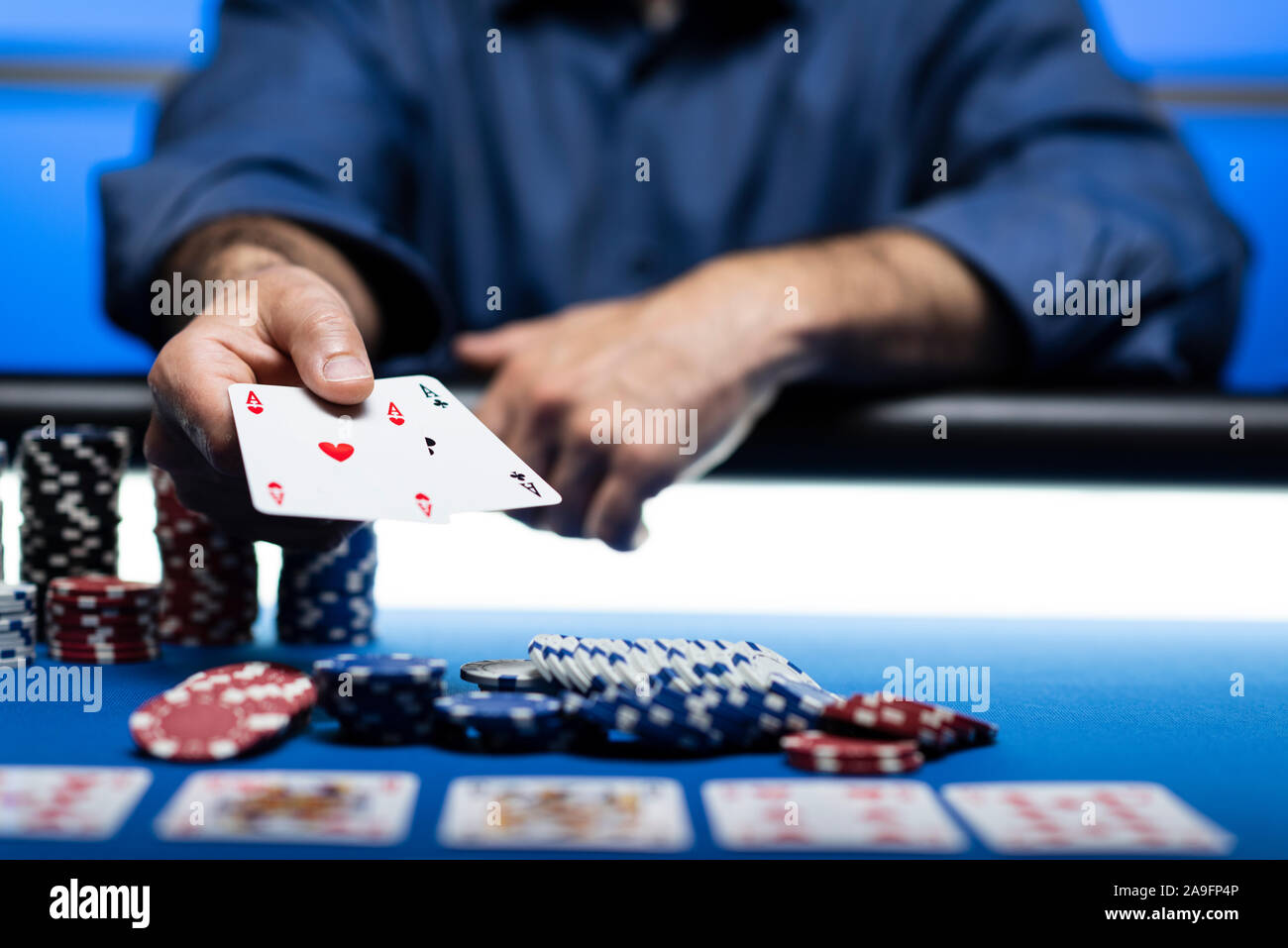 Texas Hold'em Tournoi de poker au casino : un homme tenant deux cartes de ace Banque D'Images