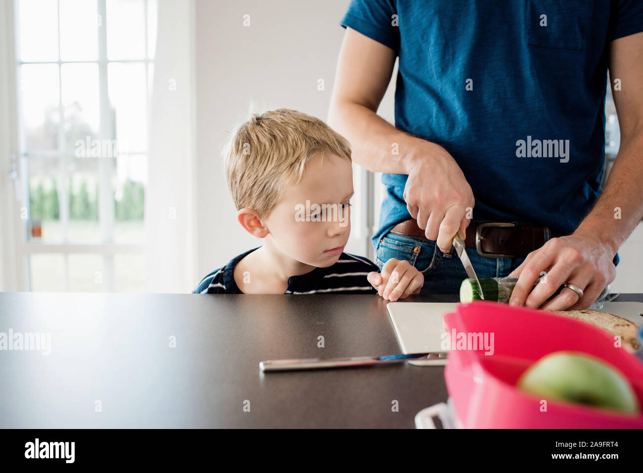 Père de faire ses enfants paniers-repas pour l'école tout en fils watches Banque D'Images