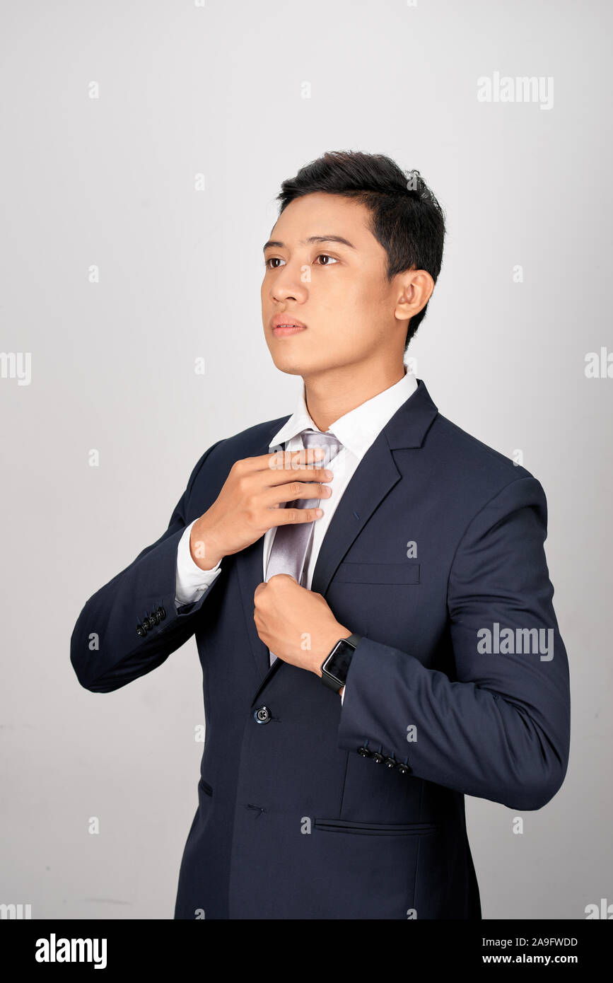 Asian Businessman adjusting tie gris, isolé sur fond blanc Banque D'Images