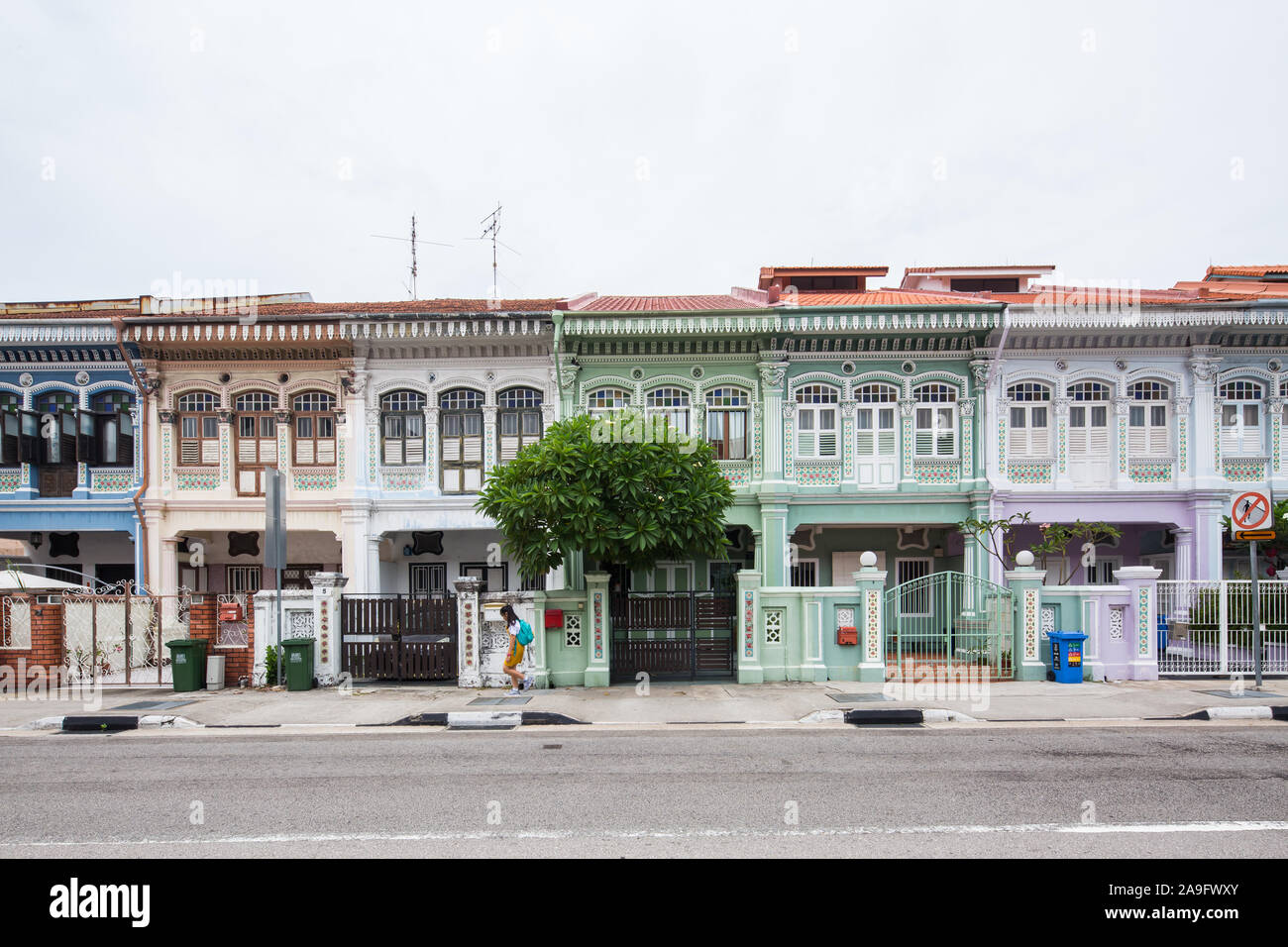 Un étudiant a marché devant une rangée de charmants Shophouse Peranakan dans le quartier de Joo Chiat, Singapour. Banque D'Images