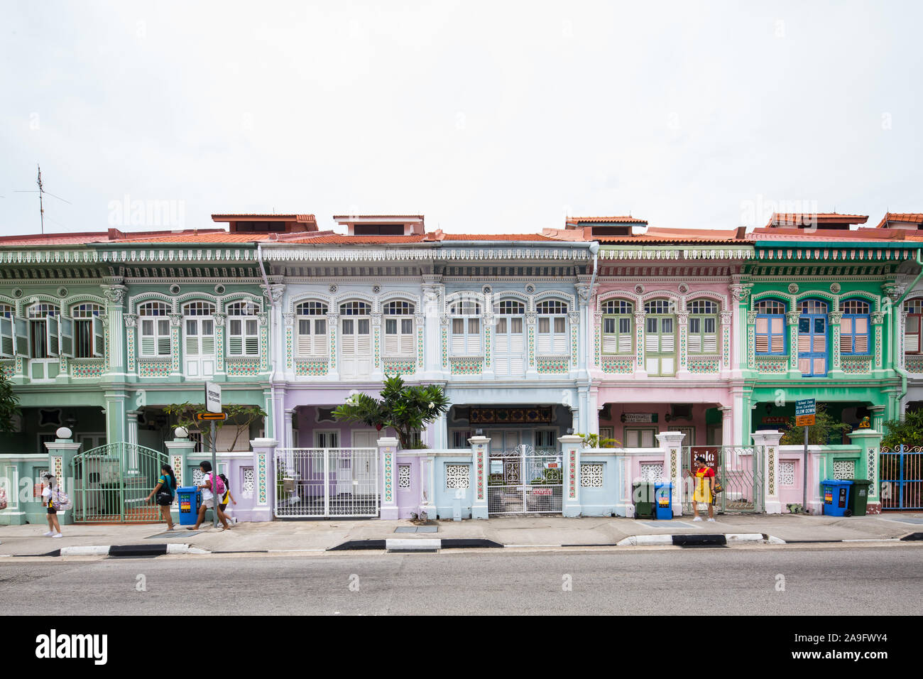 Les gens marchent devant la rangée de Peranakan Shophouse dans la zone Joo Chiat, Singapour Banque D'Images