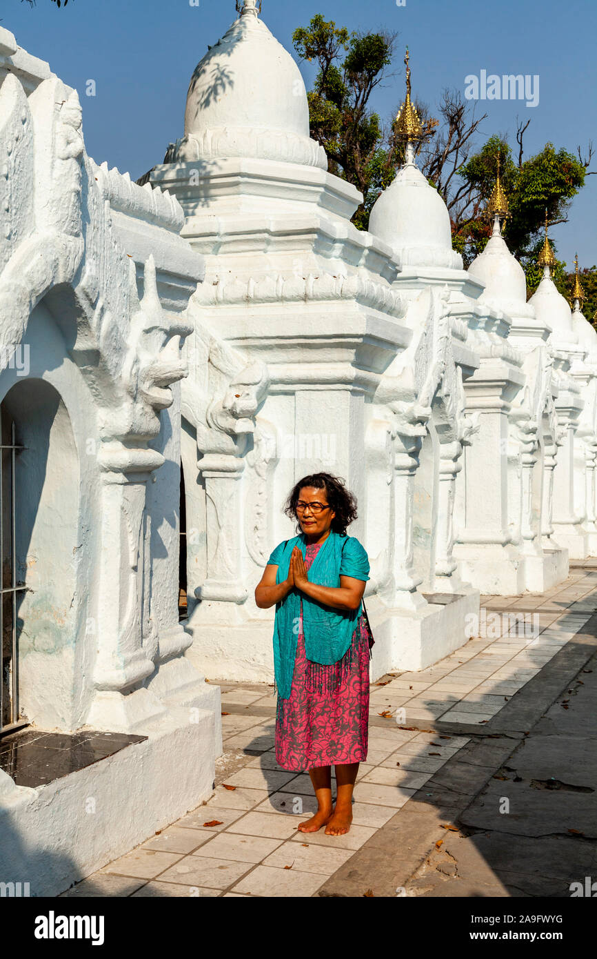 Une femme birmane en priant à la Pagode Kuthodaw, Mandalay, Myanmar. Banque D'Images