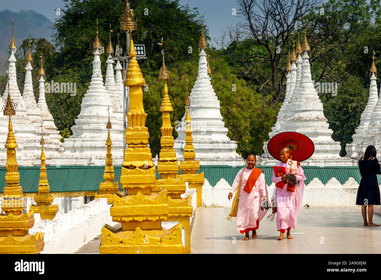 Deux nonnes bouddhistes marcher parmi les pagodes Stupas/à la Sandamuni Paya, Mandalay, Myanmar. Banque D'Images