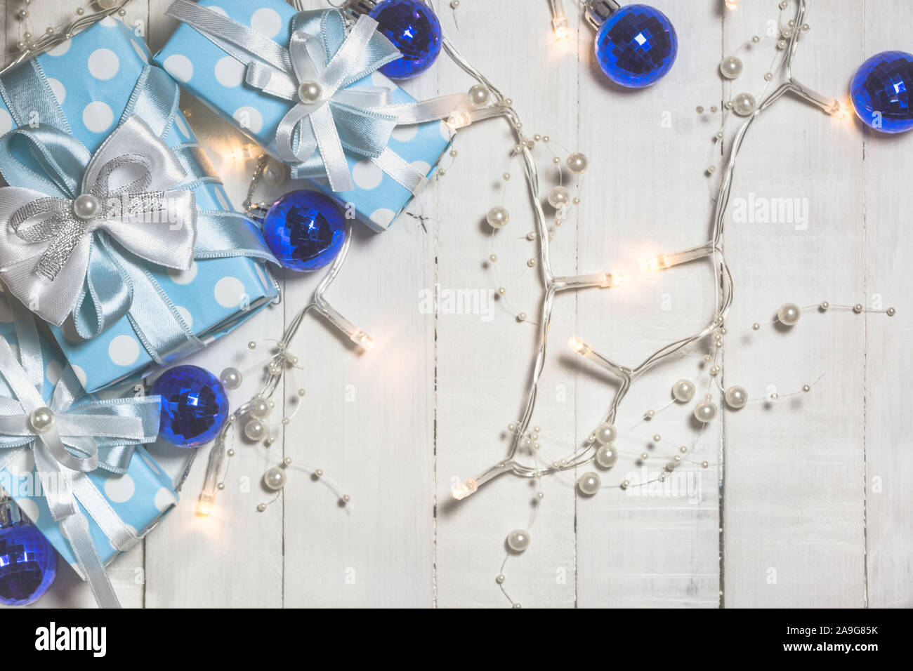 Vue de dessus de cadeaux bleu avec ruban blanc et bleu et les boules de Noël sur fond de bois blanc avec copie espace. Tons vintage photo. Le Christ Banque D'Images