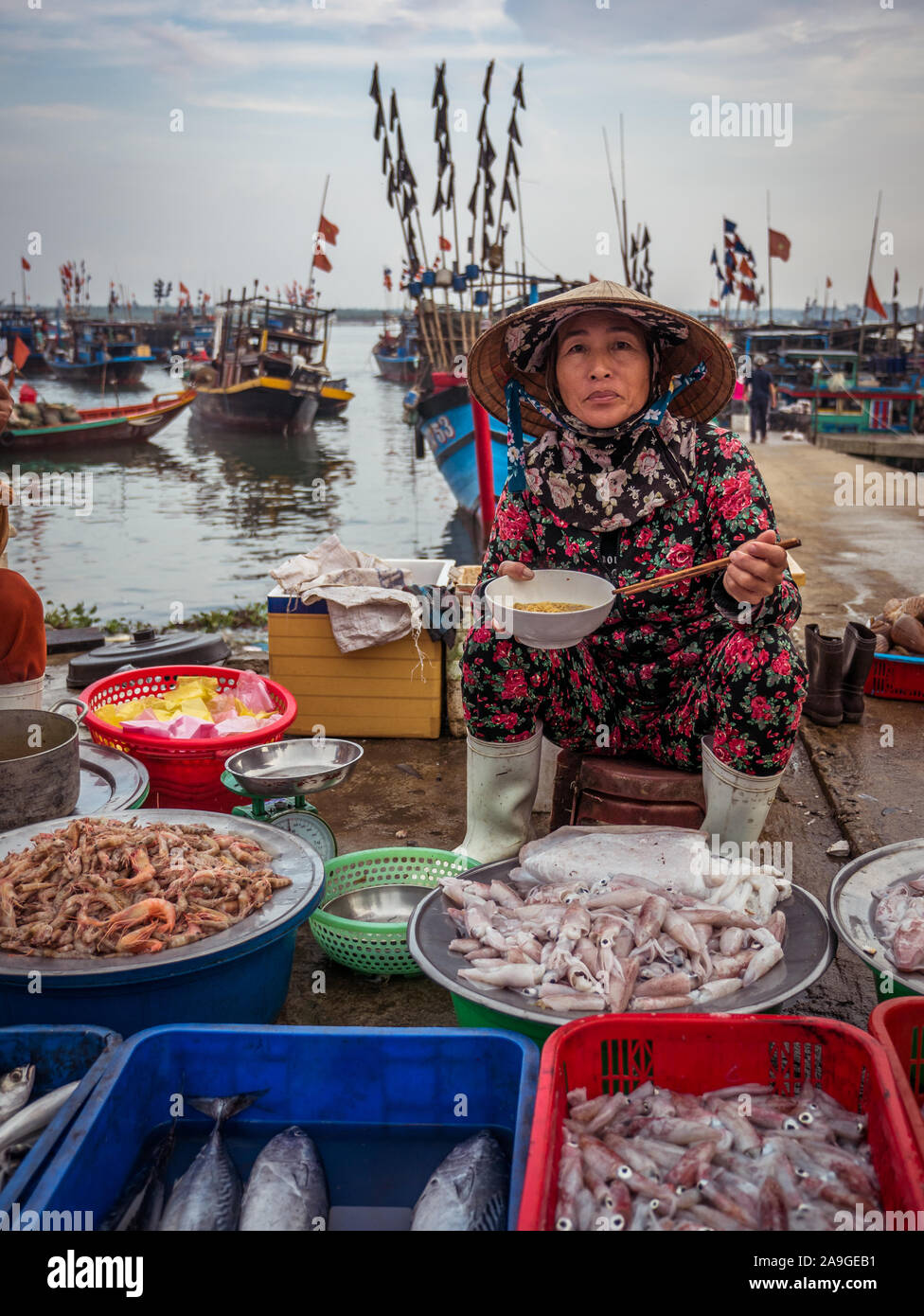 Les femmes vietnamiennes vendeur vendre du poisson frais, fruits de mer et encornets au Hoi An marché du poisson principal tout en mangeant le déjeuner le matin, Vietnam Banque D'Images