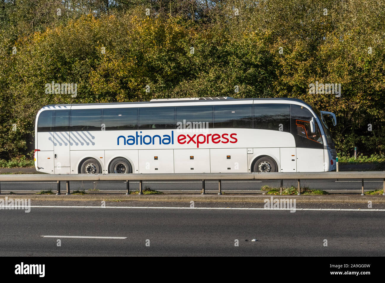 National Express Coach en voiture sur une route à deux voies, UK Banque D'Images