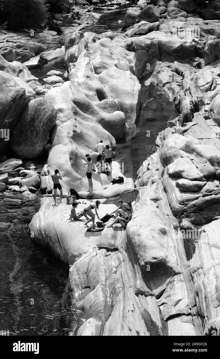 Suisse : Les personnes qui prennent un bain à la formations de pierre de la vallée de verzasca lit sec de la rivière. Banque D'Images