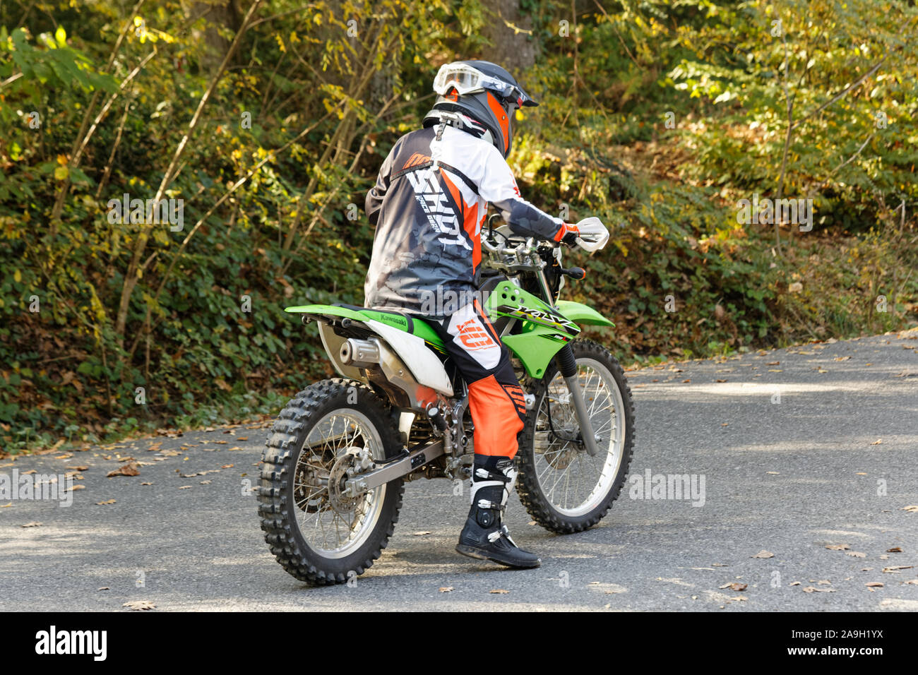 Rider motocross avec des vêtements de protection en attente sur la route  dans la forêt de Belgrade à l'automne. Vue depuis l'arrière Photo Stock -  Alamy