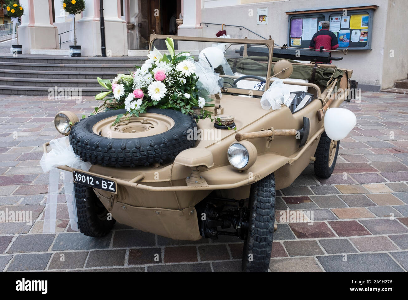 Un véhicule amphibie Schwimmwagen WWII est la voiture de mariage improbable ici stationné à l'extérieur de l'église à Ortisei, Italie Banque D'Images
