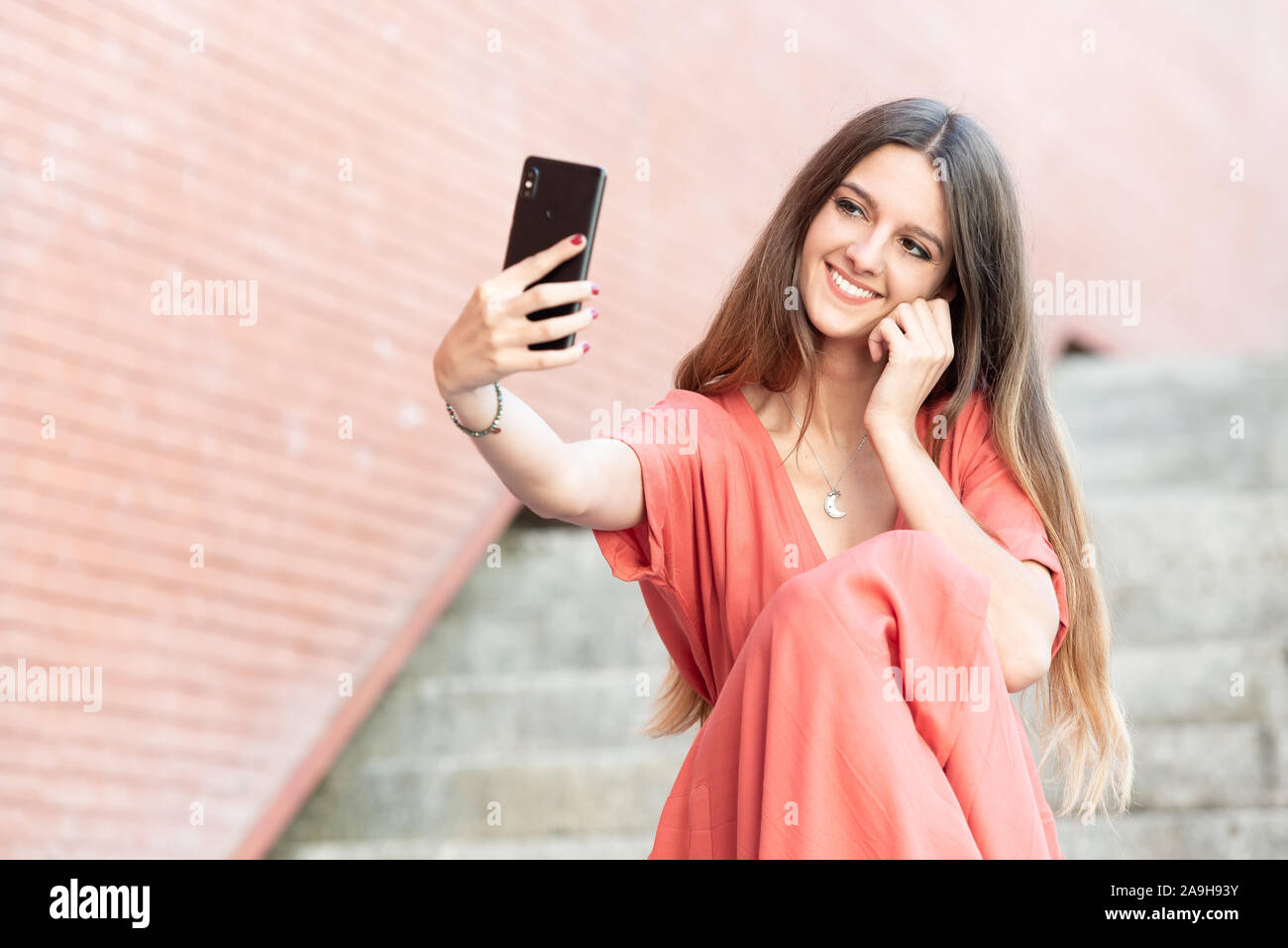 Belle jeune femme prend un téléphone mobile sur selfies Banque D'Images