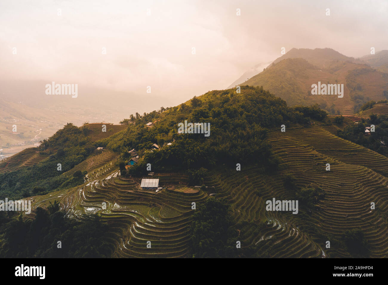 Belle Vue aérienne du lever du soleil sur les rizières en terrasses de Sapa au Vietnam du Nord au cours de l'automne comme les nuages passent sur les sommets des montagnes Banque D'Images