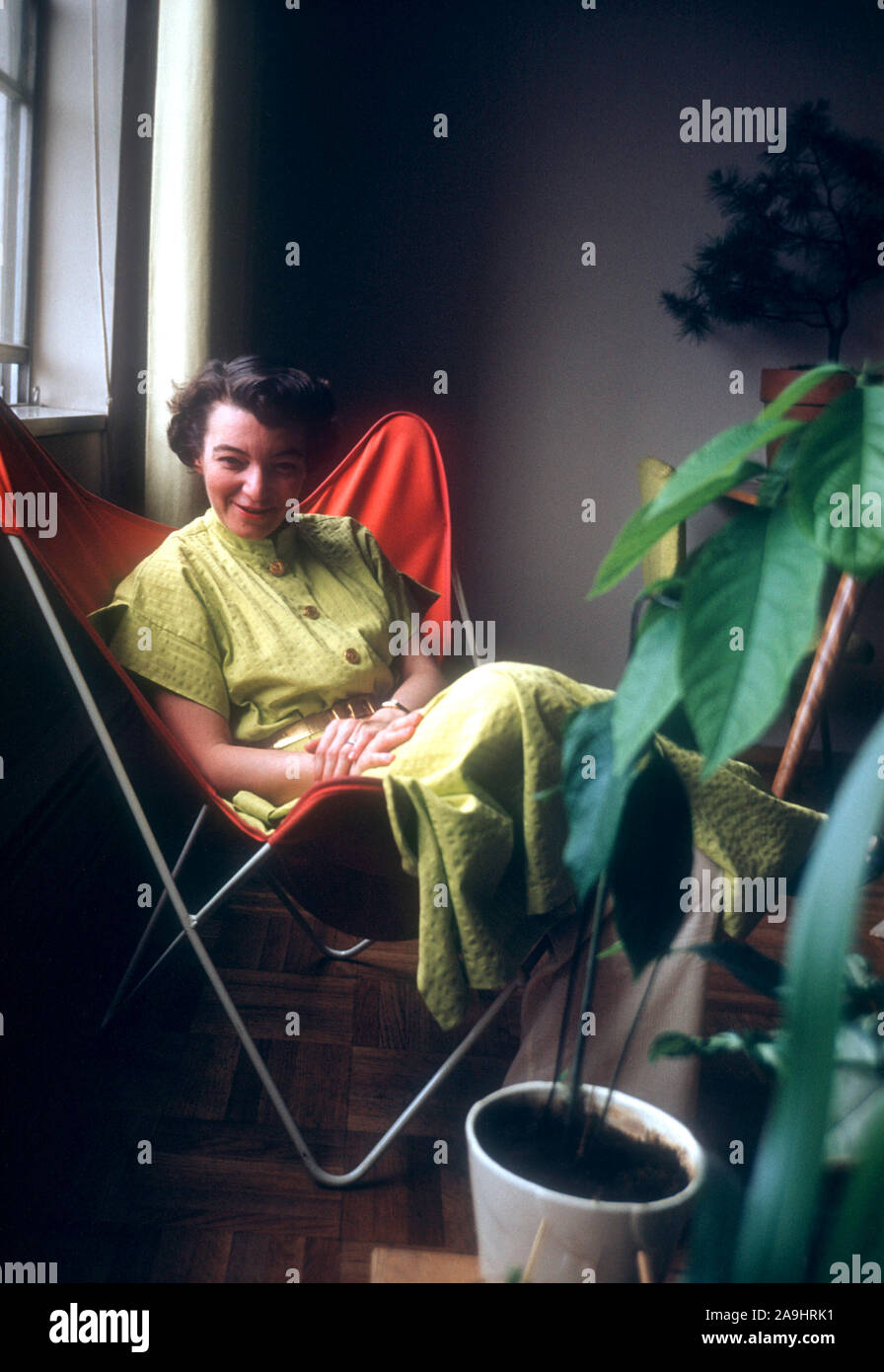 22 mars : vue générale d'un modèle posant comme elle s'assoit sur une chaise le 22 mars, 1955. (Photo de Hy Peskin) Banque D'Images