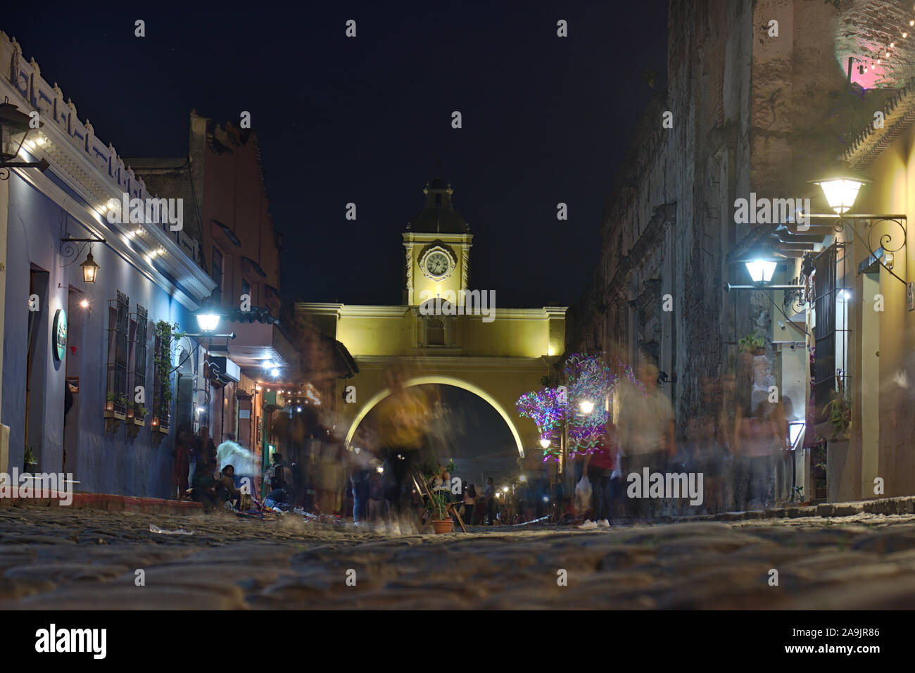 El arco au Guatemala dans la nuit éclairée par des lumières de rue avec des gens qui marchent dans la rue. Banque D'Images