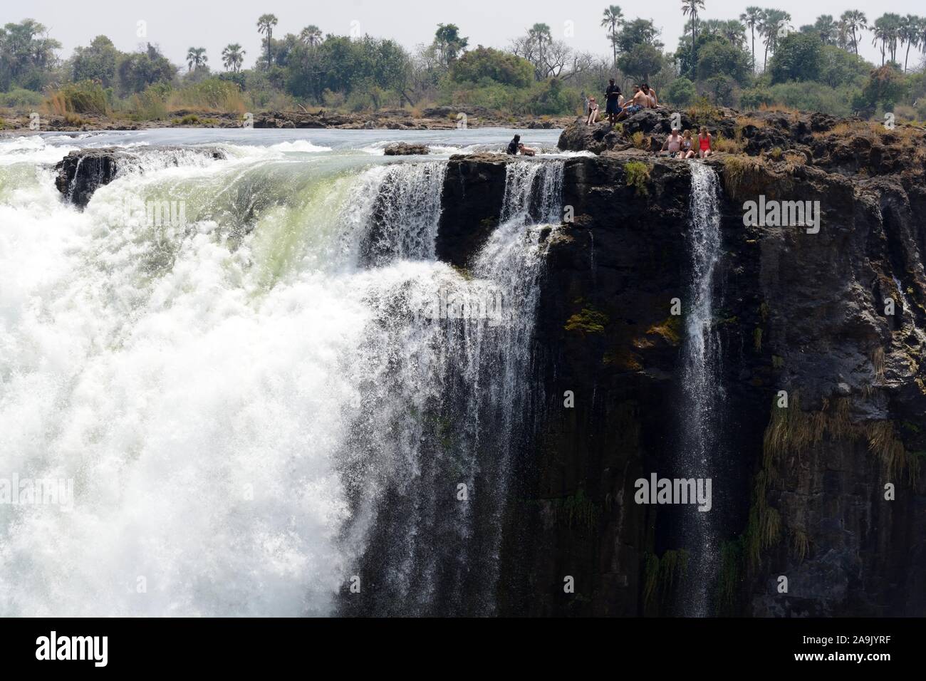Les touristes les gens en natation Piscine Devils sur le bord de l'île de Livingstone en Zambie Chutes Victoria prises à partir de l'Afrique côté Zimbabwe Banque D'Images