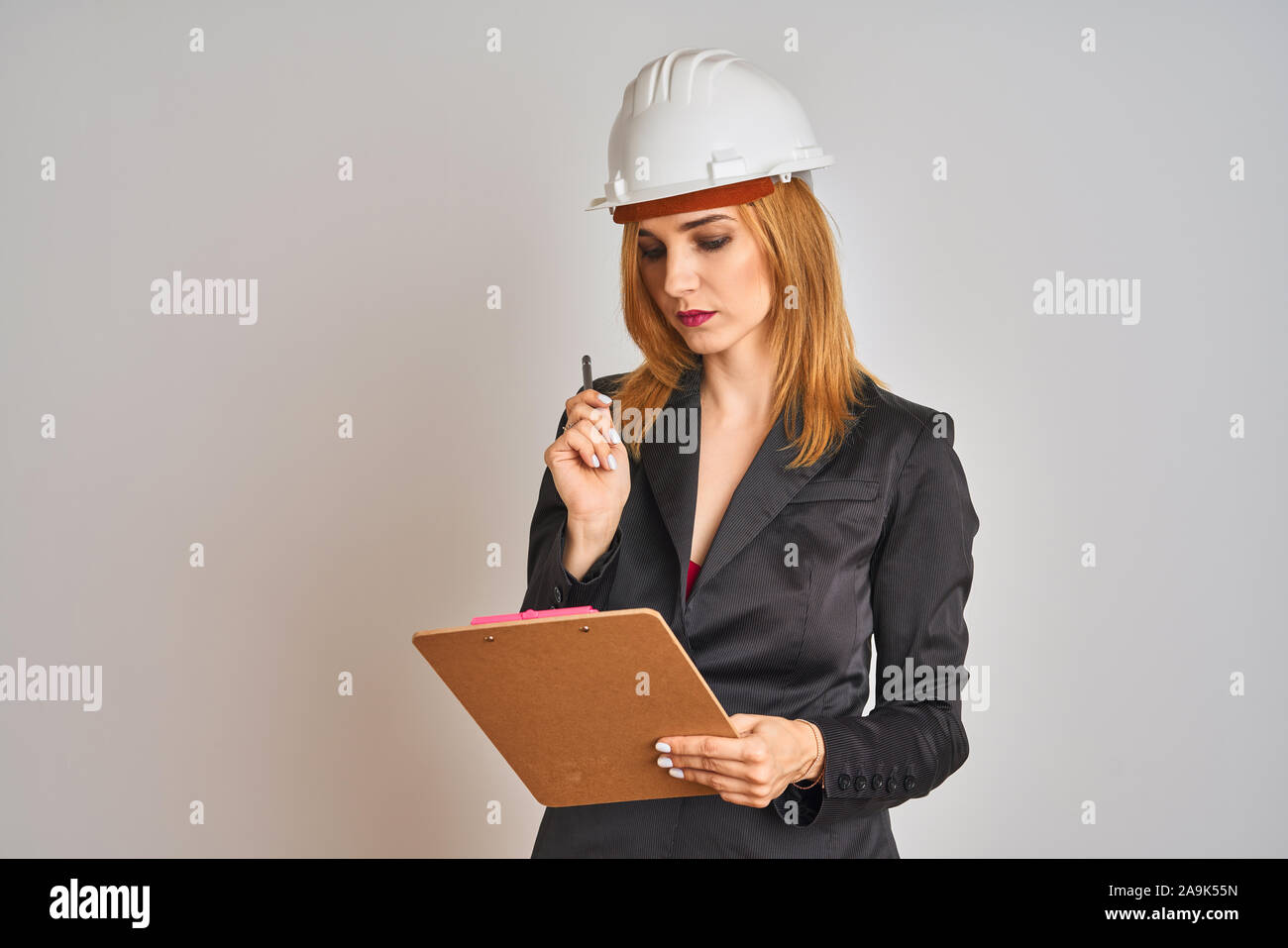 Belle jeune femme rousse architecte portant costume et hardhelmet la tenue  d'un tableau Photo Stock - Alamy
