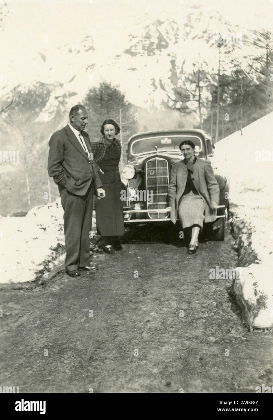 Petit groupe familial à côté d'une voiture dans les montagnes, Italie Banque D'Images