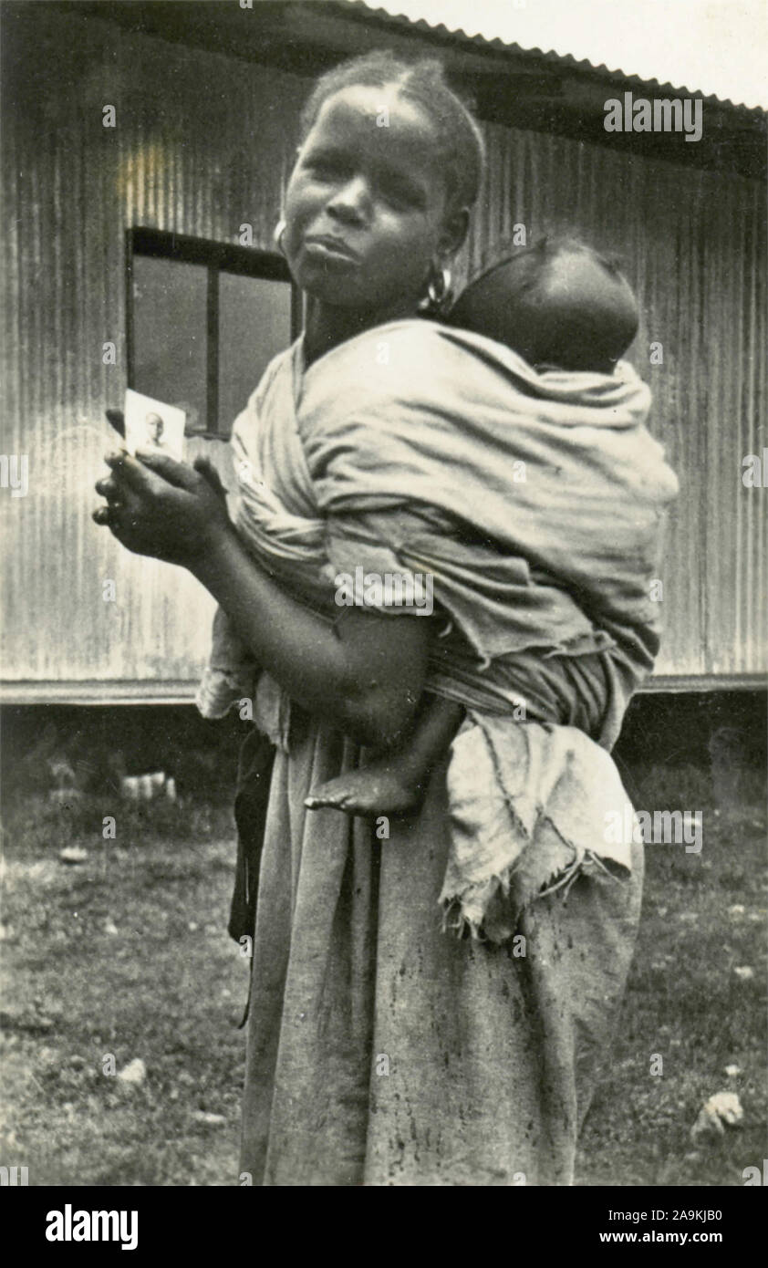 Une femme avec un enfant sur ses épaules , Afrique de l'Est Banque D'Images